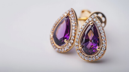 Elegant gold earrings featuring purple gemstones surrounded by sparkling diamonds. isolated on white background