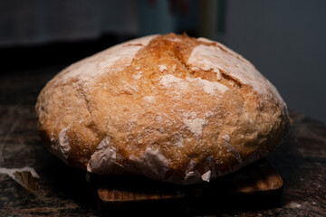 loaf of bread on a table being sliced with knife