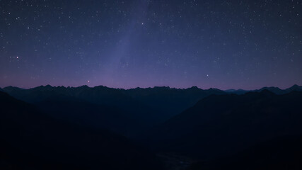 Naklejka premium high hills, mountains, and a dark purple starry sky