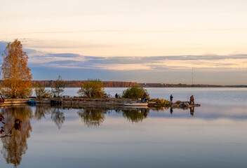 Fishermen at the cape in the lake on an autumn morning.