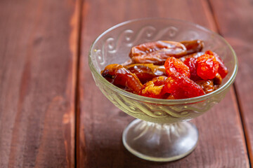 Dogwood, dried dates large sweet in glass container on wooden table