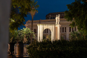 Obraz premium Illuminated arch with statues in Giardino Bellini at night, Catania, Sicily