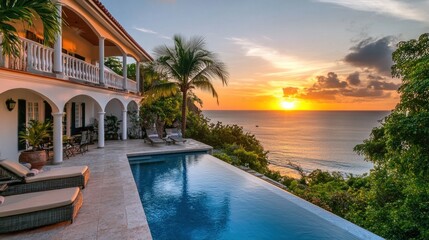 A breathtaking beachfront villa with a pool overlooking the ocean at sunset. 