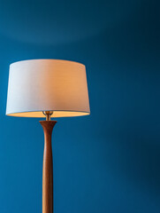 Modern floor lamp with wooden base against blue wall