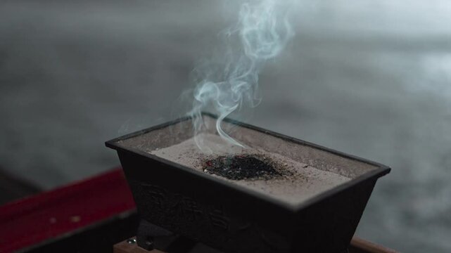 夜のお寺で白い煙を上げる焼香