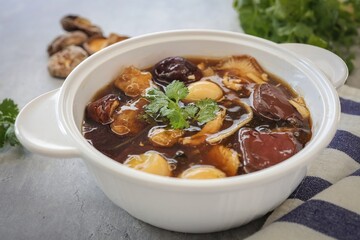 Fish maw soup in a white bowl on grey background