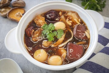 fish maw soup in a white bowl on grey background