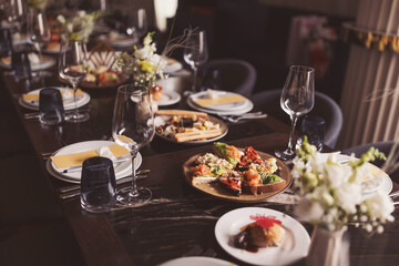 bright and festive table in the restaurant hall. Table setting in the restaurant. Brunch table setting with different delicious food ready for friends home party. A variety of food on the table