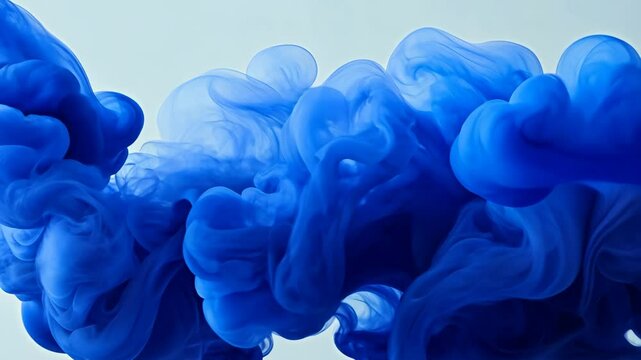 Blue swirling ink in water creating mesmerizing patterns and textures