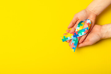 Autism ribbon. Autism awareness day. World autism awareness day with puzzle pattern ribbon on textured background. Colorful puzzle ribbon. Medicine concept. Space for text. Copy space