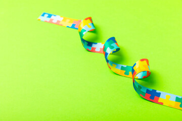 Autism ribbon. Autism awareness day. World autism awareness day with puzzle pattern ribbon on textured background. Colorful puzzle ribbon. Medicine concept. Space for text. Copy space