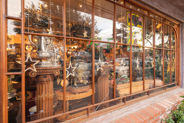 Window display reflecting the background scene in the glass.
