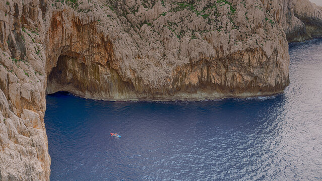 Tropical landscape. Kayak on crystal clear water among rocks and stones. View from above. Sardinia