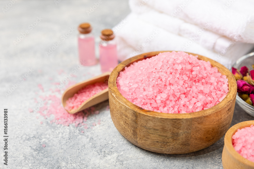 Poster Sea salt for bath with aroma and rose flowers on textured wooden background. Pink sea salt. Spa treatments. Natural salt with herbs and essential oils. skincare concept. Meso for text. Copy space