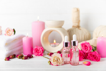 Rose essential oil on a textured background.Roses and a bottle of rose perfumed water.Aromatherapy treatment. Beauty concept. Spa procedure.Natural organic oil.Anti-stress,detox relax.Place for text