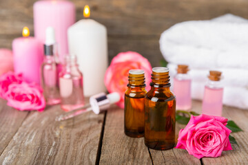 Rose essential oil on a textured background.Roses and a bottle of rose perfumed water.Aromatherapy treatment. Beauty concept. Spa procedure.Natural organic oil.Anti-stress,detox relax.Place for text