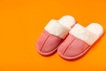 Soft slippers on a bright colored background, close-up. House slippers. Comfortable shoes for home. Foot care concept. Home comfort. Space for text. Copy space.
