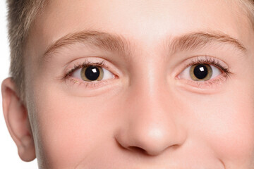 A detailed close-up captures the eyes of a child. The focus is on their irises and the surrounding skin's texture. The expression is calm and neutral.