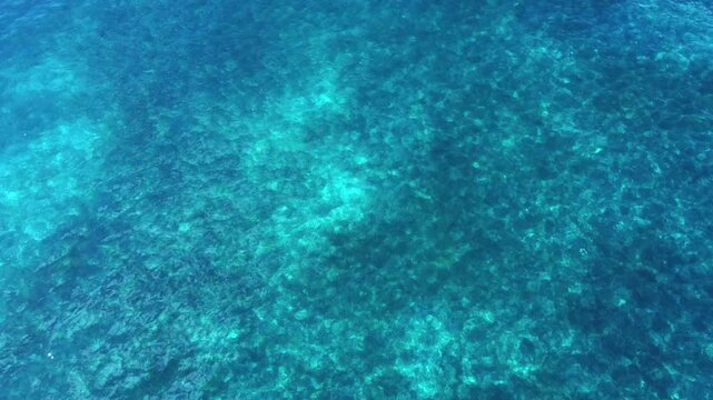 High angle aerial view of sunlight created wave pattern in turquoise tropical waters. Good background image for a variety of applications
