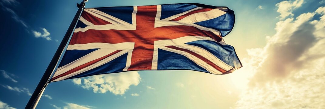 The iconic Union Jack flag flutters under a cloudy sky.
