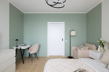 A Modern Minimalist Bedroom Design featuring Soft Green Accent Walls and Chic Decor