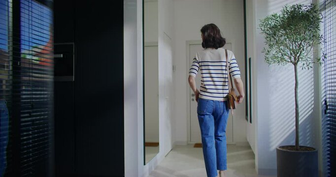 Casual Outfit Styled Within a Modern Interior Setting Filled with Bright and Natural Light. Charming Caucasian girl coming up close to mirror. Carrying small purse on shoulder. Going on date