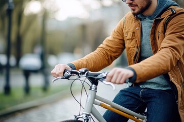 Obraz premium Bicyclist in a cozy jacket rides through a sunlit urban park on a brisk autumn day