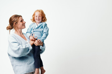 Happy family moment woman holding little girl up in air, traveling together on white background