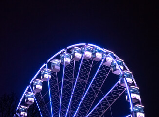 A vibrant Ferris wheel illuminated against the night sky, capturing the excitement and joy of a festive celebration