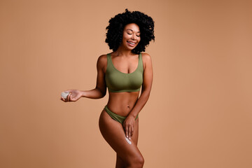 Photo of body positive lady applying cream lotion legs soft hydrating skin isolated pastel color...