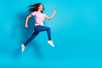 Obraz premium Full length photo of cheerful pretty lady dressed pink t-shirt running jumping high empty space isolated blue color background