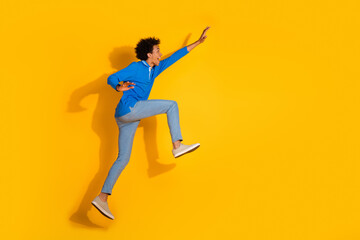 Full length photo of handsome young guy excited running hurry dressed stylish blue garment isolated...