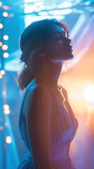 Elegant woman in a purple dress, posed under colorful stage lights.