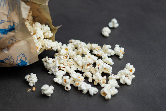 Fresh popcorn in bag made in a microwave on grey kitchen table