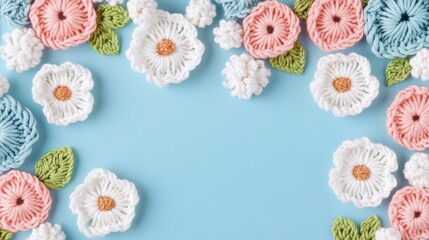 Fototapeta premium This image showcases beautifully arranged crocheted flowers against a soft blue background, perfect for crafting themes.