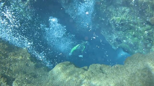 Underwater view of divers diving into a cave in Ichetucknee Springs, Florida, USA.