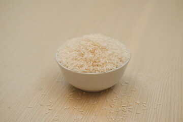 Rice in a bowl on wooden background. Close up.