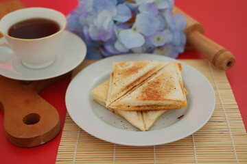 Toasted bread on a white plate isolated on a red background.