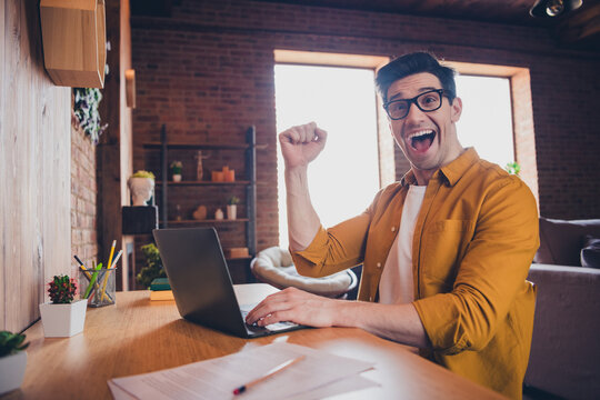 Cheerful young man enjoying a relaxed weekend at home in a stylish loft living room - Powered by Adobe