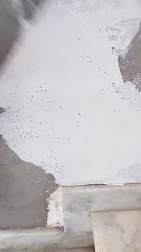 Worker applying spackle to wall
