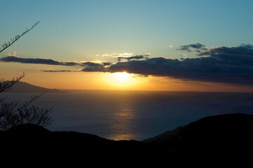 A stunning sunrise over the horizon in Japan, with sunlight reflecting off the ocean and creating a radiant path on the water.