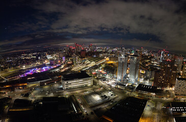 Fototapeta premium As night falls, Manchester transforms with colorful city lights and illuminated buildings creating a mesmerizing urban landscape filled with energy.