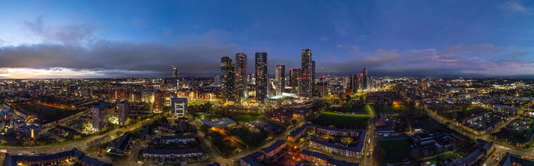 A captivating aerial shot of Manchester during dusk, showcasing the city's skyline with an enchanting blend of city lights and fading twilight colors.