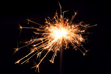 Close up of burning handheld sparkler as background