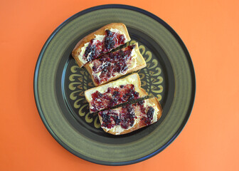 Toasted white bread with butter and blackberry jam.