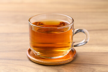 Black tea in cup glass on wooden background, Healthy herbal drink