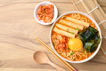 Spicy noodles soup with Tteokbokki, Wakame seaweed and fresh egg yok eating with kimchi cabbage