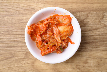 Kimchi cabbage in bowl on wooden background, Korean food side dish, Table top view