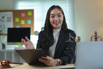 Young lawyer woman having video conference with client on laptop, explaining legal advice and...