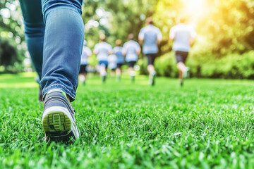 Enthusiastic Group of Runners Training on a Lush Green Lawn in a Bright Stadium Environment